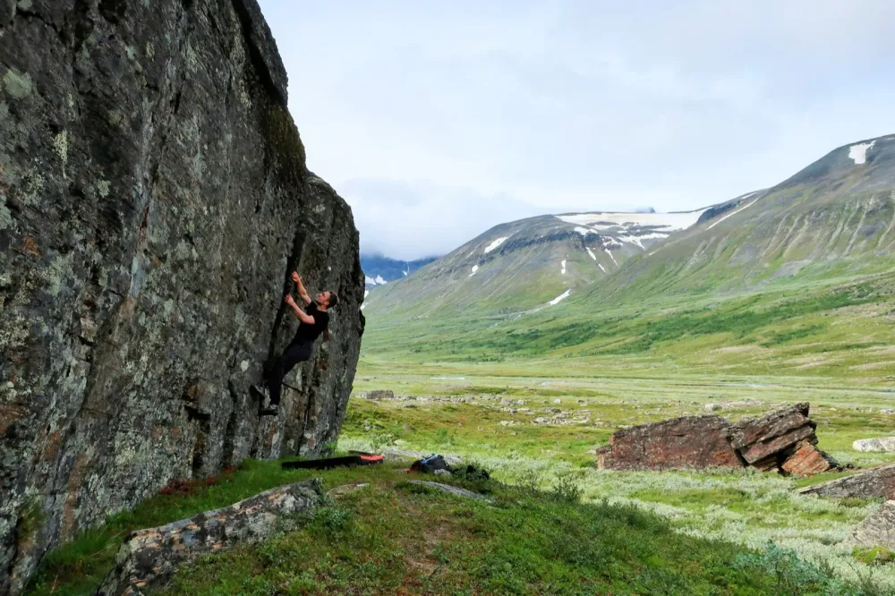 Johannes bouldering in a mountain valley
